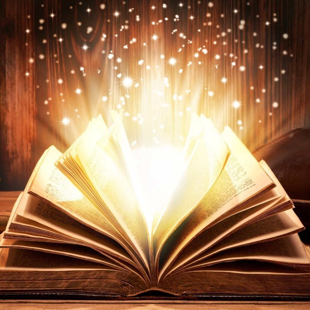 An open book with glowing stars flying out of it.
