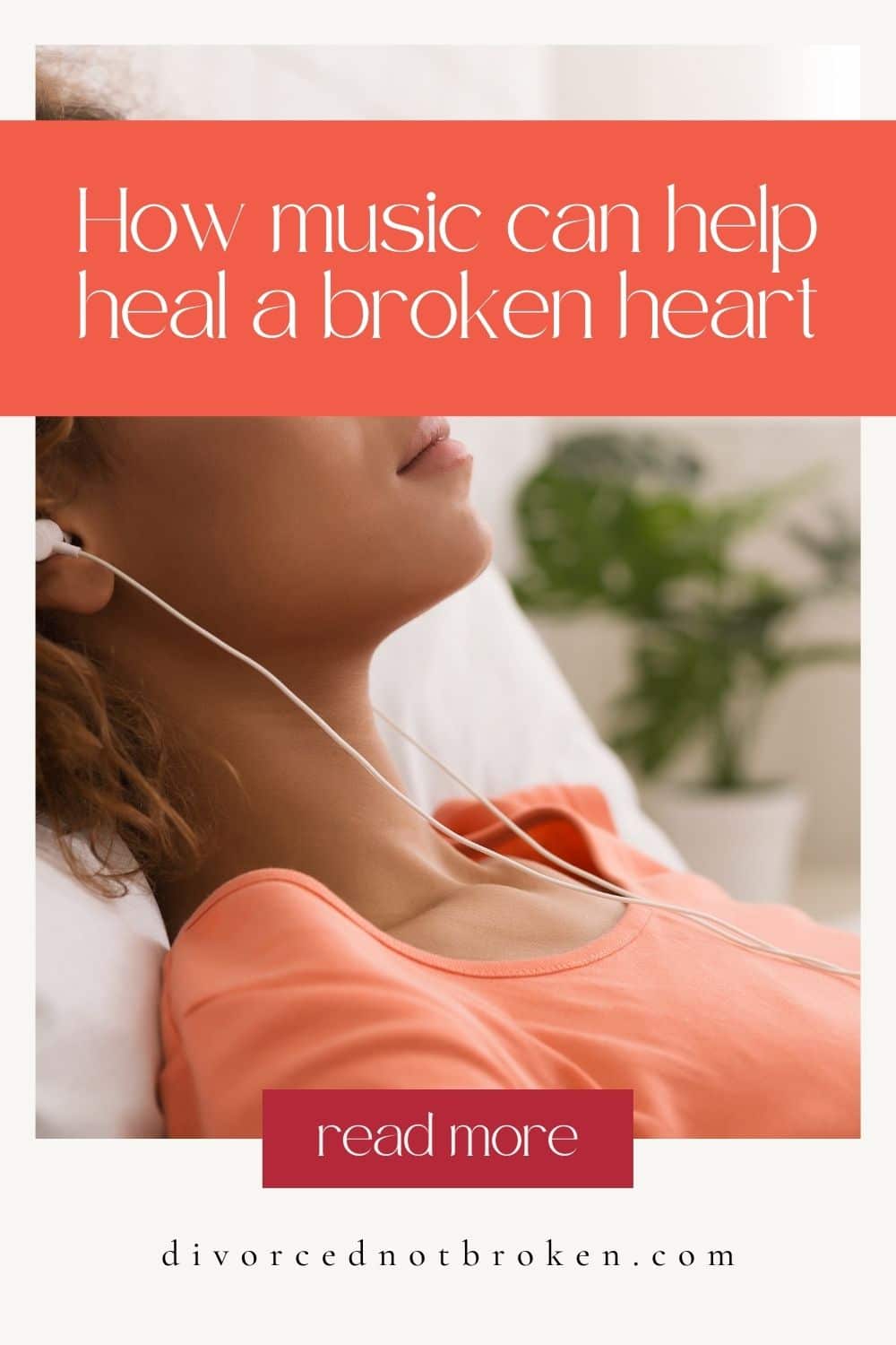 A black woman wearing an orange shirt leaning against a pillow listening to music with headphones. 