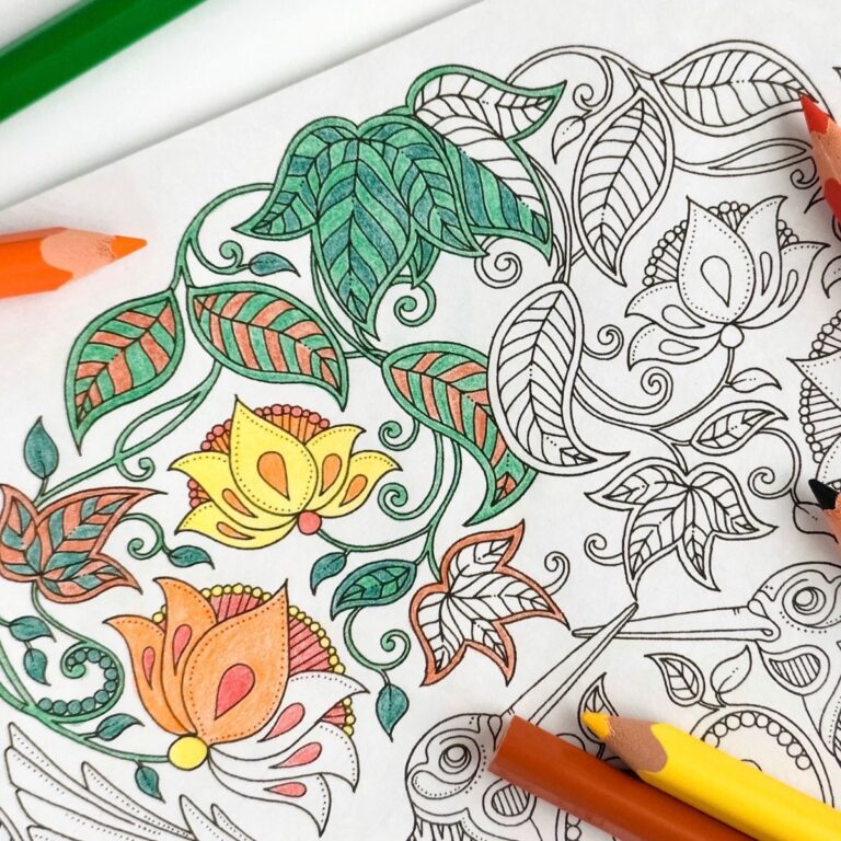 A floral coloring book page with green, yellow and orange pencils.